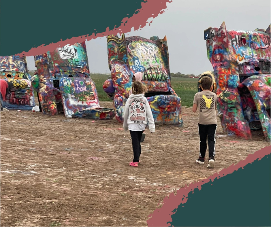 Kids spray painting colorful graffiti on vintage Cadillacs at Cadillac Ranch in Amarillo, Texas