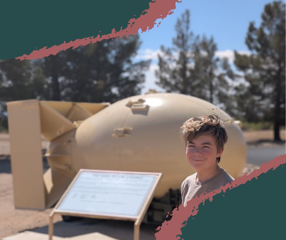 Young boy at White Sands Missile Range Museum standing in front of a "Fat Man" bomb replica, learning about the nuclear age and Cold War history.