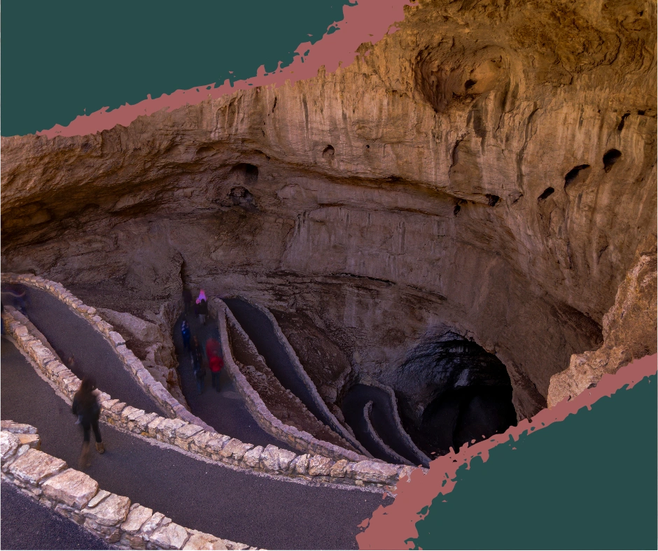 Natural entrance to Carlsbad Cave with rocky edges and descending walking trail hidden beneath in the Guadalupe Mountains in New Mexico.