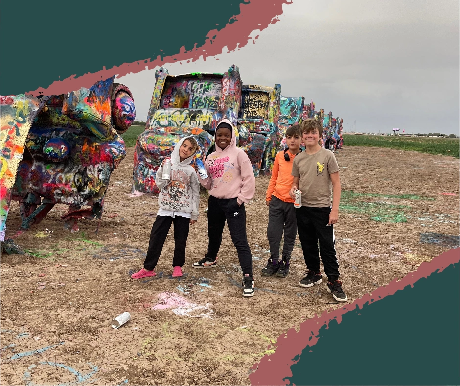 Kids spray painting cars at Cadillac Ranch in Amarillo, Texas on a cloudy day. Amarillo TX Cadillac Ranch.