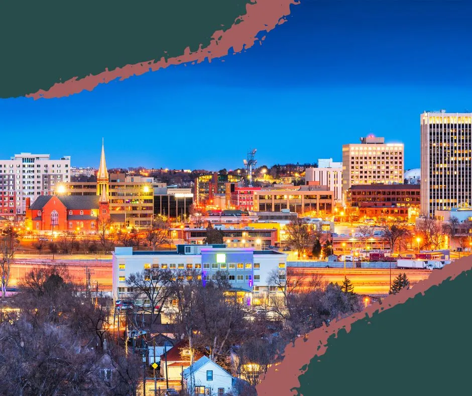Cityscape of Colorado featuring downtown buildings, a museum, and the Barry Goldwater Visitor Center, with mountain views and world-class training centers nearby.