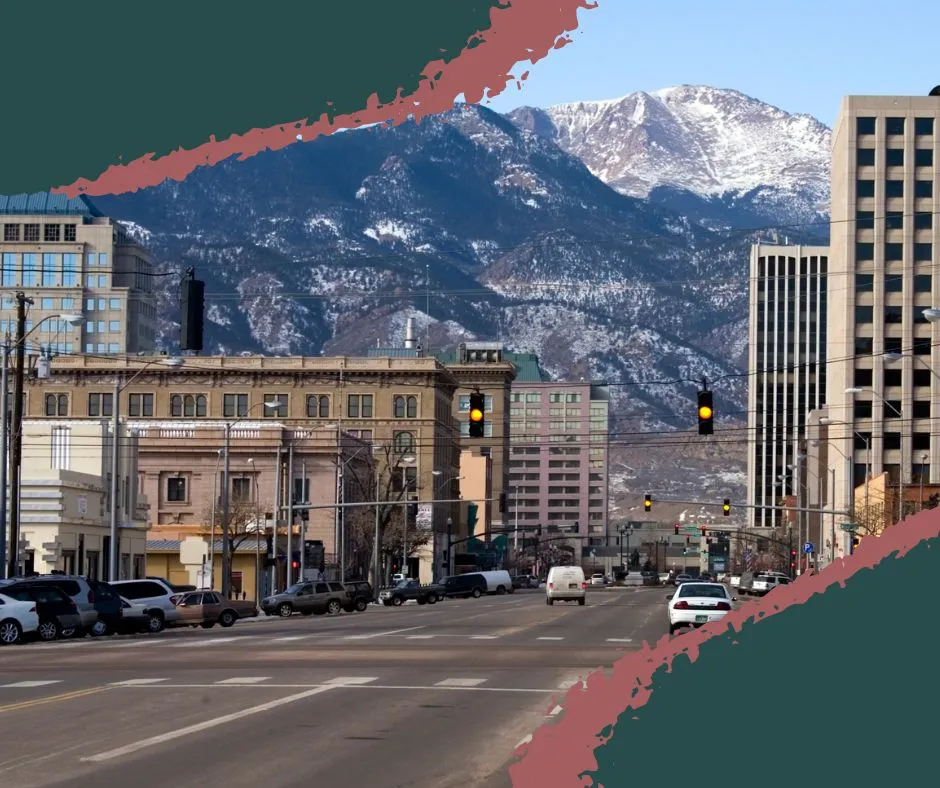Historic town view near Old Colorado City, Colorado, featuring a museum, Barry Goldwater Visitor Center, and streets lined with shops and local ice hockey banners.